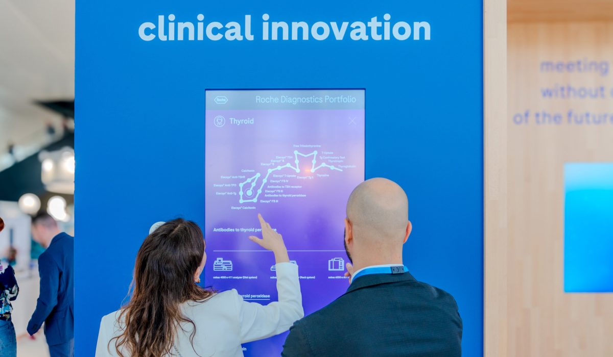 Two healthcare professionals are engaging with the interactive Body Map app at a clinical innovation station.